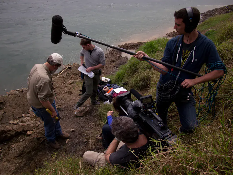 Field documentary crew filming near the water in China